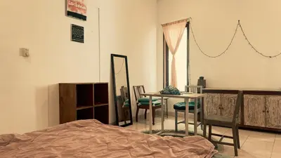 a room with a bed and a table and chairs at kerobokan cozy house by kenta in Seminyak