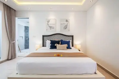 a bedroom with a large bed with blue pillows at Villa Hugo in Canggu