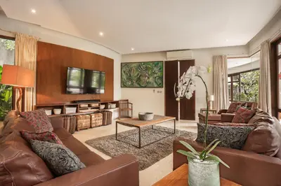 a living room with a couch and a table at Umah Daun by Nakula in Canggu