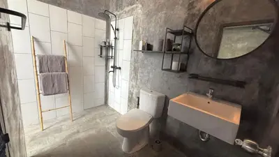 a bathroom with a sink and a toilet and a mirror at Ambara Villa - Quiet Luxury in Umalas in Canggu