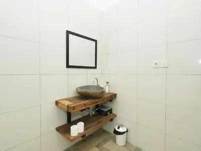 a bathroom with a bowl sink on a wooden shelf at The White House Villa Taeyvela Seminyak in Seminyak
