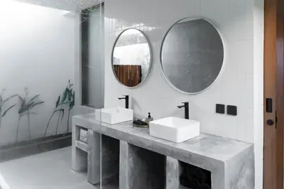 a bathroom with two sinks and two mirrors at Villa Under the Sun - Seminyak in Seminyak