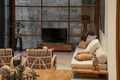 a living room with a couch and chairs and a television at Villa Under the Sun - Seminyak in Seminyak