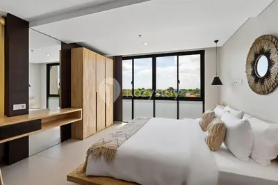 a bedroom with a white bed and a large window at Sariha by Kozystay - Nusa Dua in Nusa Dua