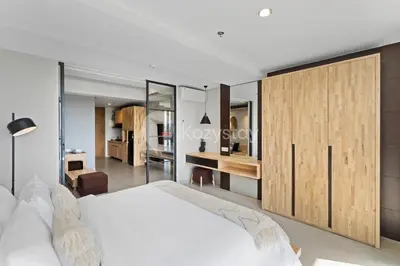 a bedroom with a white bed and a desk at Sariha by Kozystay - Nusa Dua in Nusa Dua