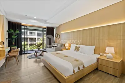 a bedroom with a bed and a living room at Rivana by Kozystay - Nusa Dua in Nusa Dua