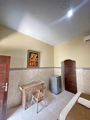a bathroom with a table and a small refrigerator at OSA Guest House in Seminyak