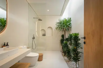 a bathroom with a shower and a toilet and plants at Brand New Exquisite Luxury 5 BR Villa Umalas in Kerobokan