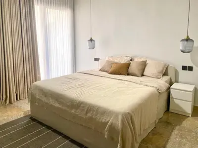 a bedroom with a large bed and a window at Zen Home in Jimbaran