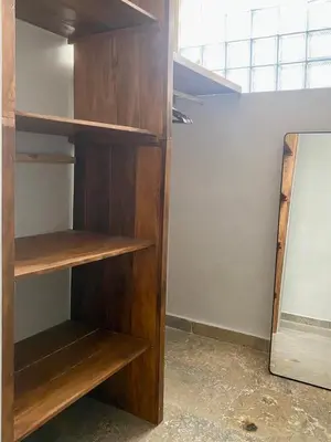 a closet with wooden shelves in a room at Zen Home in Jimbaran