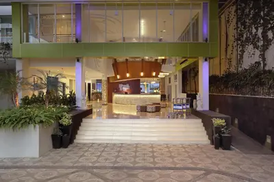 a lobby of a building with a staircase in the middle at Diamond Hotel Kuta Bali in Kuta