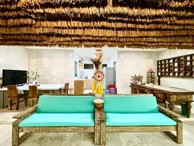 a room with a couch and a table with a clock at LAVENDER STAR HOUSE h in Kuta