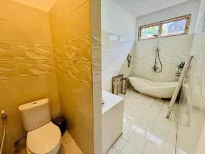 a bathroom with a toilet and a tub and a sink at Villa Ohana 2 BR Family villa with pool in Umalas in Kerobokan