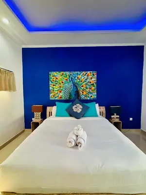 a blue bedroom with a large bed with towels on it at Villa Ohana 2 BR Family villa with pool in Umalas in Kerobokan