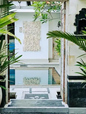 a stairway with plants and a painting on the wall at Villa Ohana 2 BR Family villa with pool in Umalas in Kerobokan