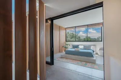 a bedroom with a blue bed and a window at Villa Kanan Seminyak - Stylish 2BR Villa Private Pool in Seminyak