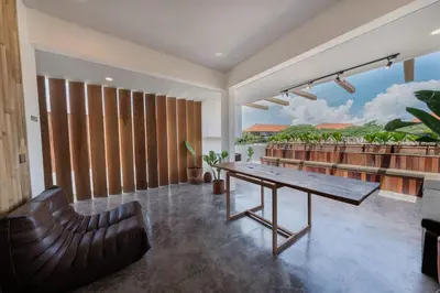 a living room with a wooden table and a bench at Villa Kiri - Modern 2BR Hideaway Rooftop & Private Pool in Seminyak