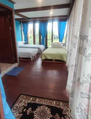 two beds in a room with blue walls and windows at Bashania in Kerobokan