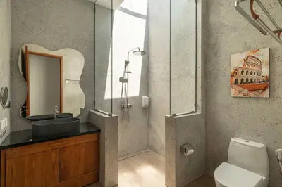 a bathroom with a sink and a mirror and a toilet at Ben's Villa 2 by Alfred in Bali in Kerobokan