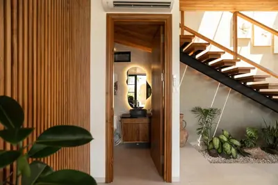 a hallway with a staircase and a mirror at Ben's Villa 2 by Alfred in Bali in Kerobokan