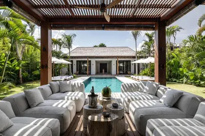 an outdoor living room with couches and a swimming pool at Villa Gendang in Seminyak