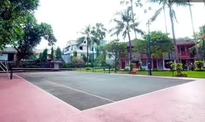 a tennis court with palm trees in the background at The Palmana Tropical Courtyard Jayakarta Residence 12 in Seminyak