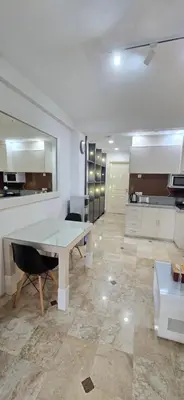 a kitchen with a table in the middle of a room at The Palmana Tropical Courtyard Jayakarta Residence 12 in Seminyak