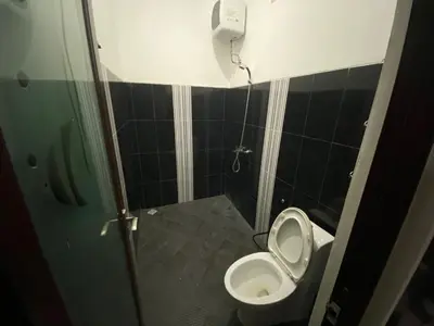 a small bathroom with a toilet and a phone at Kubu Jimbaran in Jimbaran