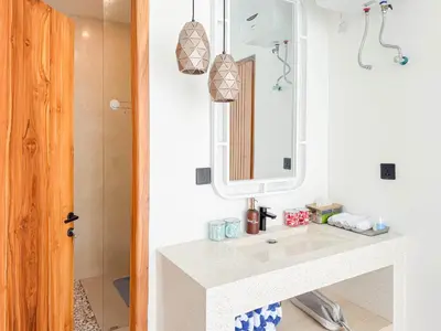 a bathroom with a sink and a mirror at Anjou - Twin Villa in Berawa Canggu in Canggu