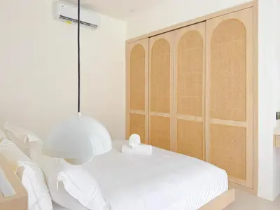 a white bedroom with a large white bed and a lamp at Burgundy - Twin Villa in Berawa Canggu in Canggu