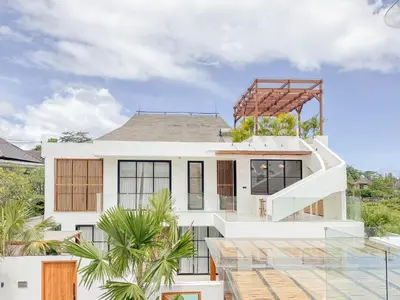 a house with a staircase on top of it at Burgundy - Twin Villa in Berawa Canggu in Canggu