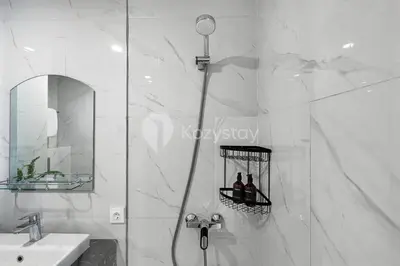 a bathroom with a shower with a sink and a mirror at Alva by Kozystay - Nusa Dua in Nusa Dua