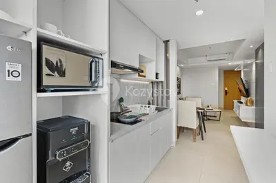 a kitchen with a microwave and a dining room at Alva by Kozystay - Nusa Dua in Nusa Dua