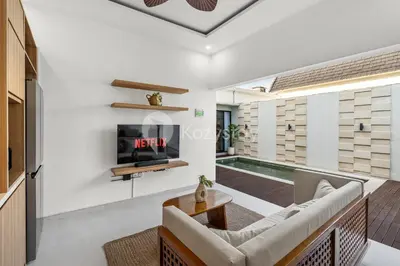 a living room with a couch and a tv at Navaya Villa by Kozystay - Seminyak in Seminyak