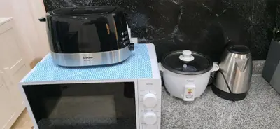 a microwave sitting on a counter next to a coffee maker at The Palmana Tropical Garden Jayakarta Residence 38 in Seminyak