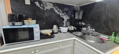 a kitchen counter with a microwave and a sink at The Palmana Tropical Garden Jayakarta Residence 38 in Seminyak