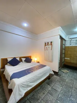 a bedroom with a large bed with blue pillows at W Hotel at Kuta Beach By Micky Studio -1 minutes to beach in Legian