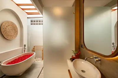 a bathroom with a white tub and a sink at Levan Villa Seminyak in Seminyak