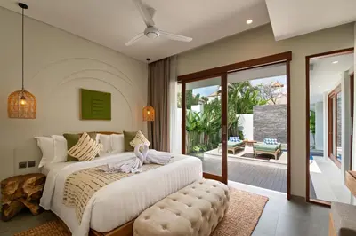 a bedroom with a large bed and a patio at Levan Villa Seminyak in Seminyak