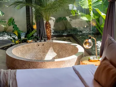 a bathroom with a tub with a palm tree in it at House of Winds Complex - Stylish 12BR Design Estate - 4 Villas near Canggu in Kerobokan