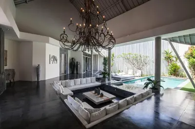 a living room with a large couch and a chandelier at House of Winds Complex - Stylish 12BR Design Estate - 4 Villas near Canggu in Kerobokan
