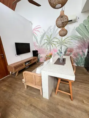 a living room with a table and a tv at Phil's Harmony Seminyak in Kerobokan