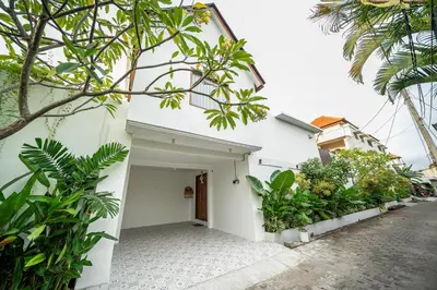 a white house with trees and plants in front of it at Villa Mai Mai Seminyak in Seminyak