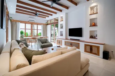 a living room with a large couch and a tv at Villa Mai Mai Seminyak in Seminyak