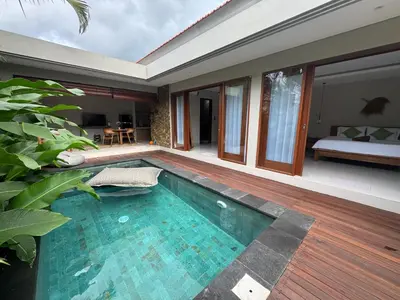 a swimming pool in front of a house at Villa Elysia in Canggu