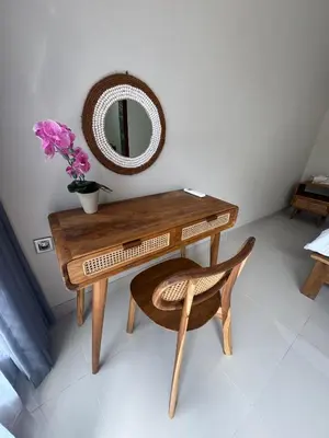 a wooden table with a chair and a mirror at Villa Elysia in Canggu