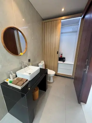 a bathroom with a sink and a toilet and a mirror at Villa Elysia in Canggu
