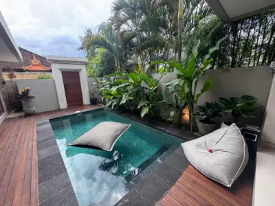 a swimming pool in the middle of a patio with plants at Villa Elysia in Canggu