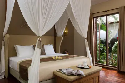 a bedroom with a bed with curtains and a window at The Secret Villas in Seminyak