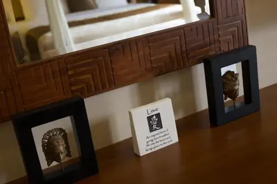 a table with three framed pictures and a mirror at The Secret Villas in Seminyak